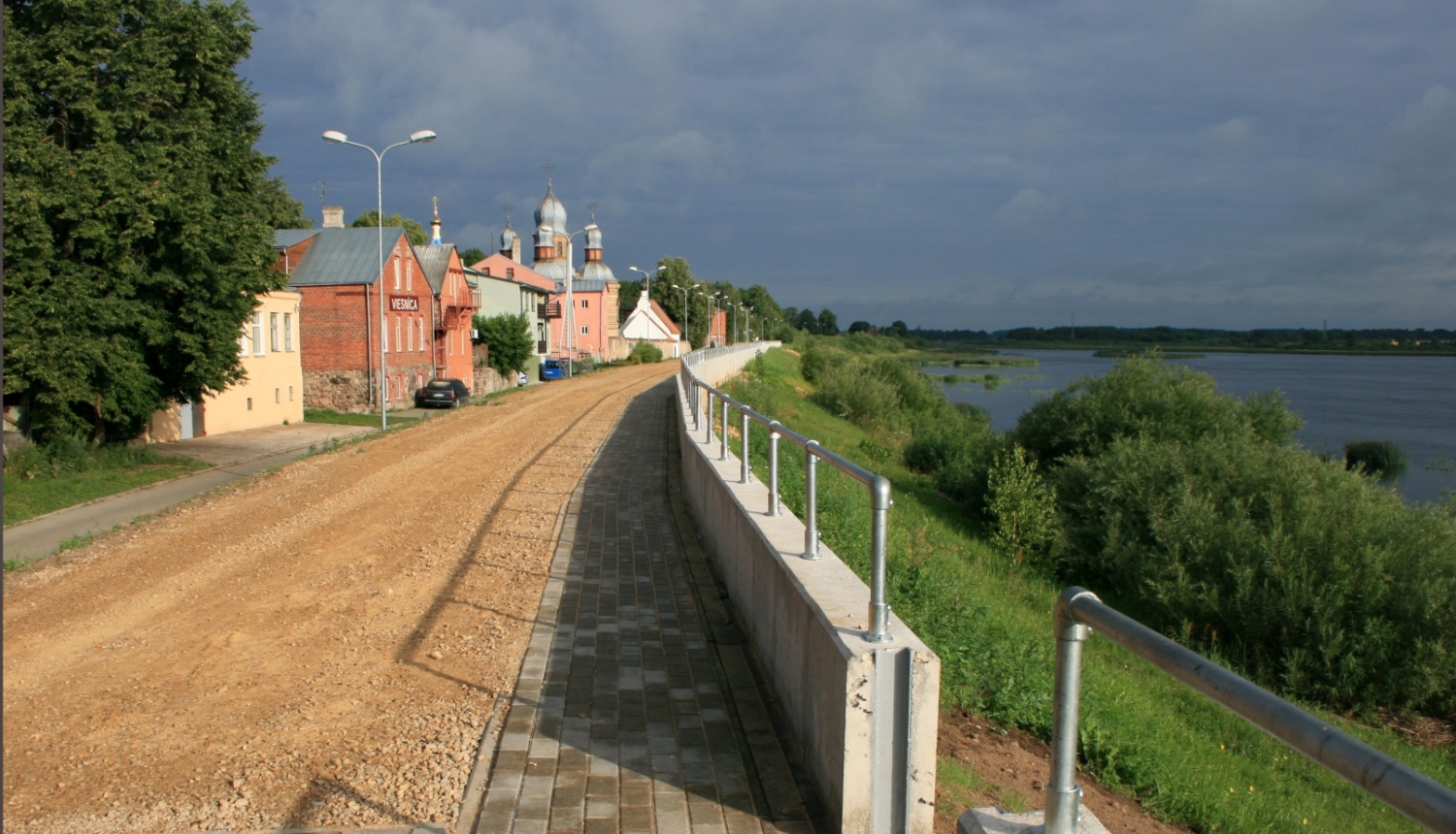 Skats uz upi un dambi, promenādi gar to