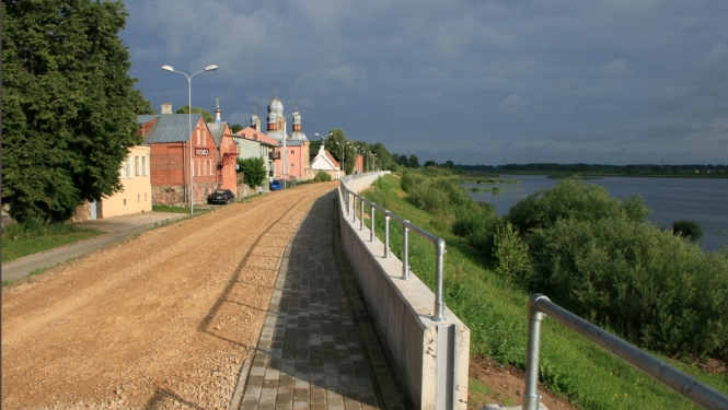 Skats uz upi un dambi, promenādi gar to