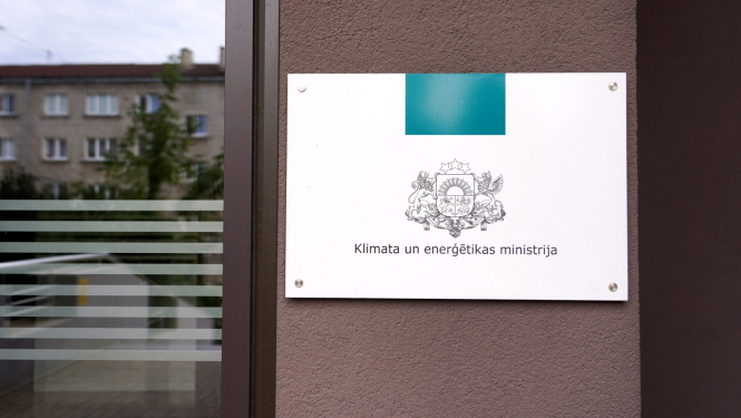 Plāksne ar KEM logo pie ieejas ēkā