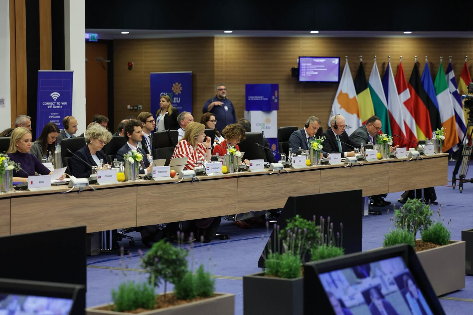 Neformālās ministru sanāksmes dalībnieki pie piedalās sanāksmē, dalībnieki sēž pie gara sanāksmju galda