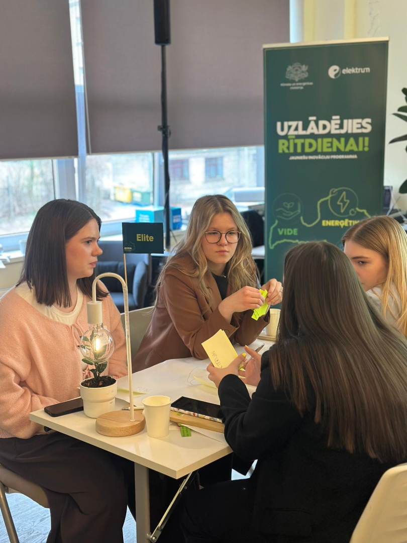 Programmas Uzlādējies rītdienai komanda apspriežas pie galda