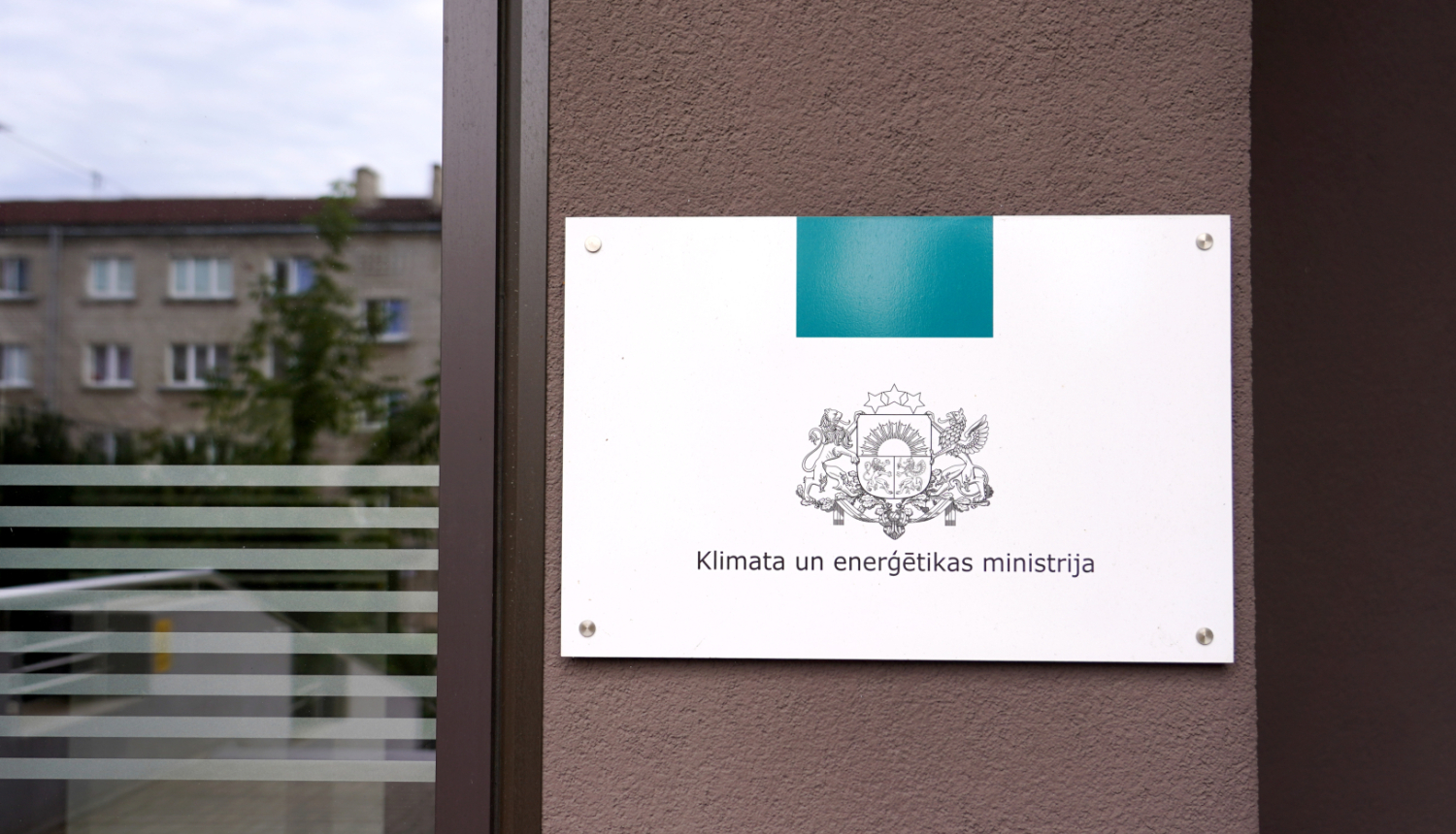 Plāksne ar KEM logo pie ieejas ēkā