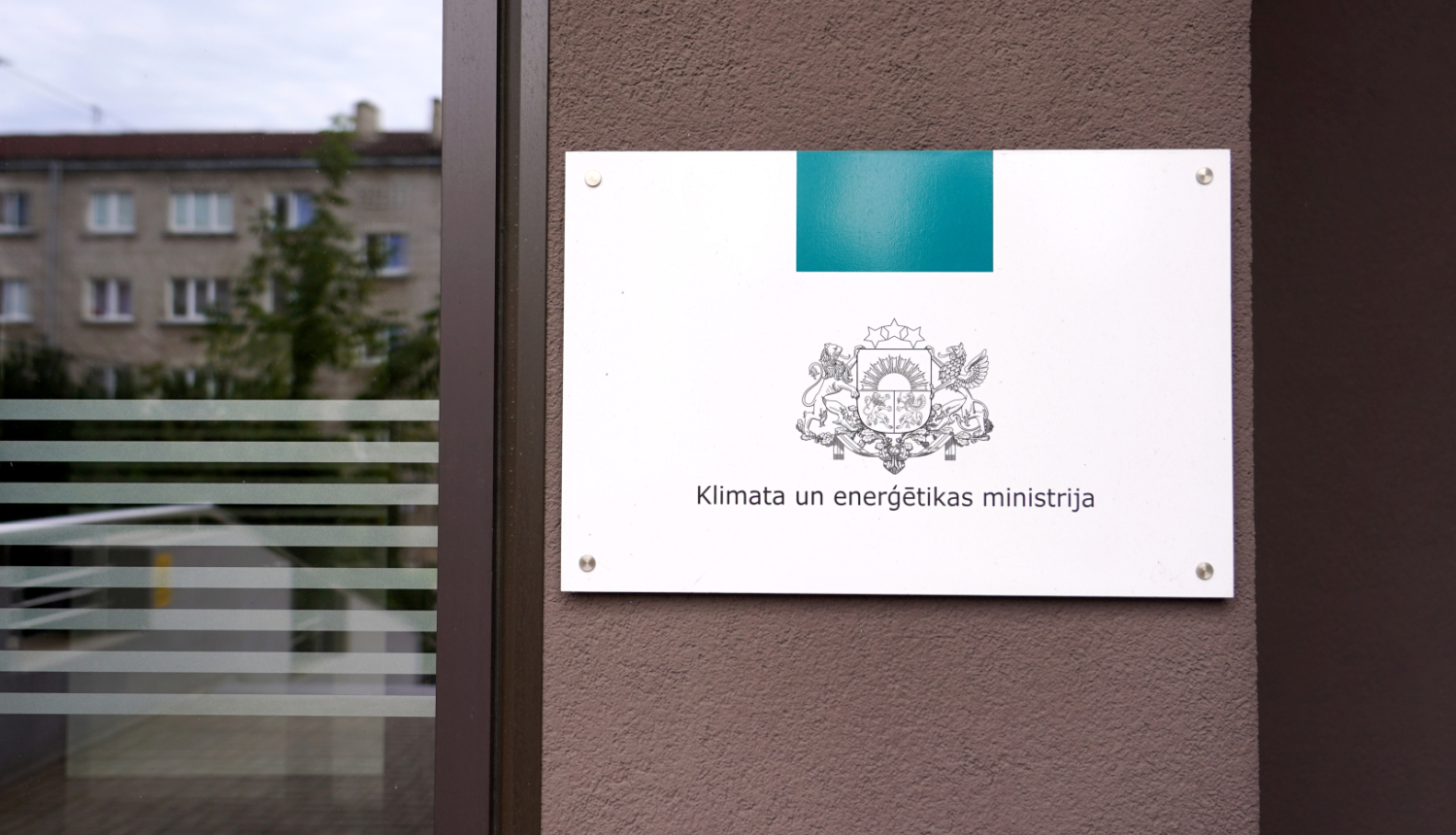 Plāksne ar KEM logo pie ieejas ēkā